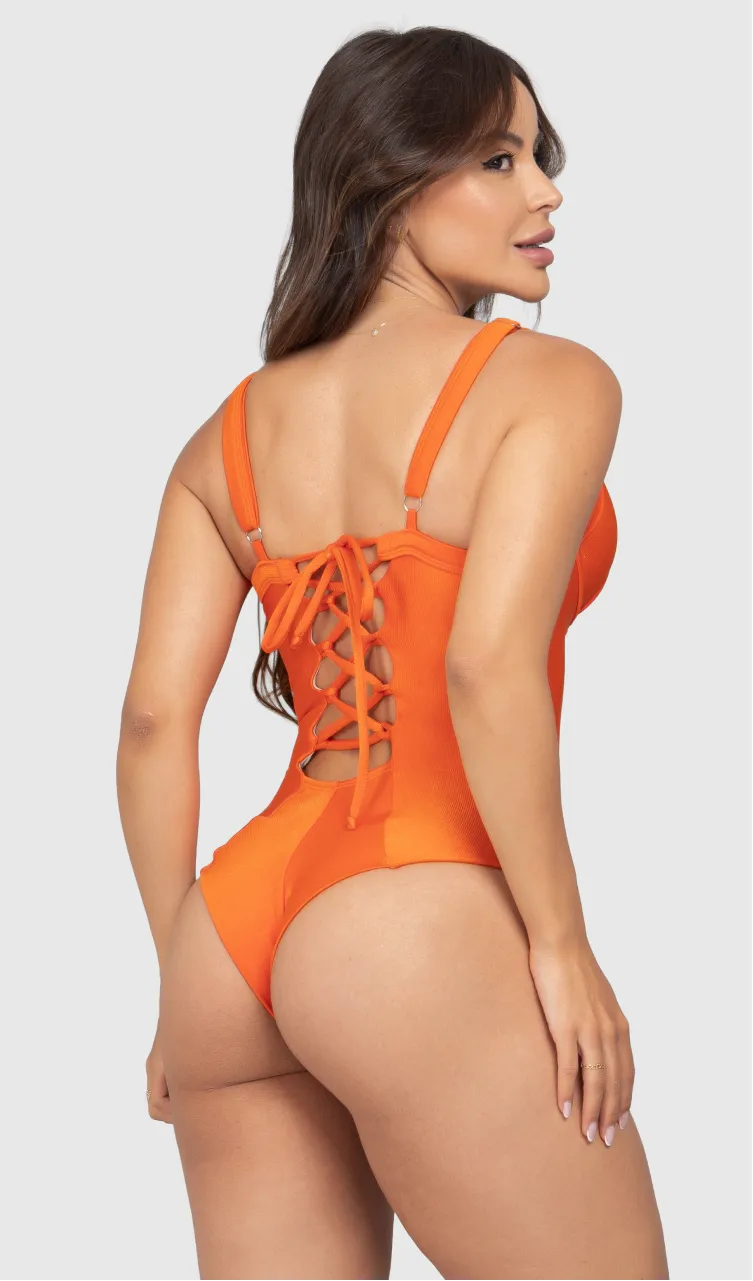 Modelo feminina de cabelos claros, de costas, em um estúdio com fundo neutro, vestindo um maiô laranja com efeito modelador. A peça é confeccionada em tecido de poliamida e elastano, com proteção solar. Maiô estruturado com sutiã meia taça com aro para sustentação, bojo, decote coração e amarração nas costas estilo espartilho.